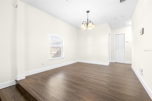 unfurnished room with dark hardwood / wood-style flooring and a notable chandelier