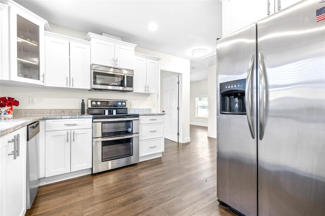 kitchen with white cabinetry, appliances with stainless steel finishes, dark hardwood / wood-style flooring, and light stone countertops