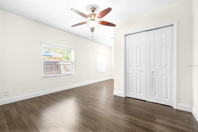 unfurnished bedroom with dark wood-type flooring, ceiling fan, and a closet