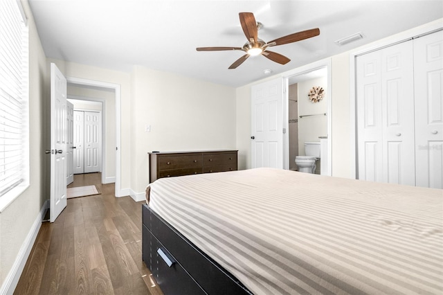 bedroom with ceiling fan, dark hardwood / wood-style floors, ensuite bath, and a closet