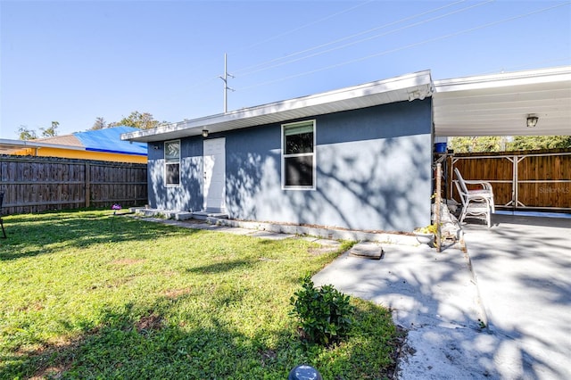 back of property featuring a lawn and a patio