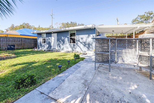 back of property with a yard and a patio area