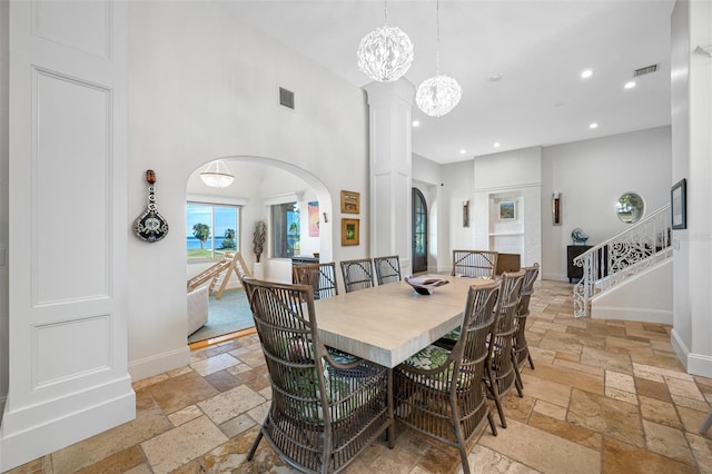 dining area with a towering ceiling and a notable chandelier