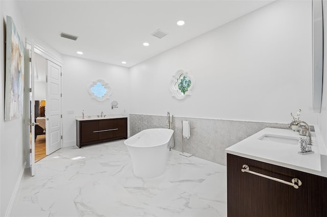 bathroom featuring a bathing tub, vanity, and tile walls