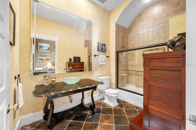 bathroom with tile patterned floors, toilet, and enclosed tub / shower combo