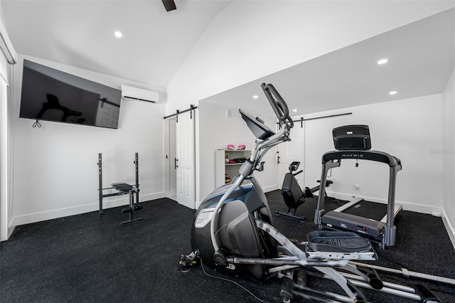 workout area with a barn door, a wall unit AC, and lofted ceiling