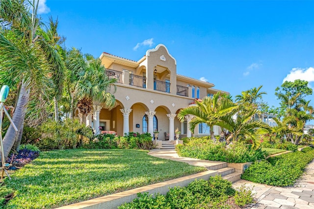 mediterranean / spanish-style house with a balcony and a front lawn