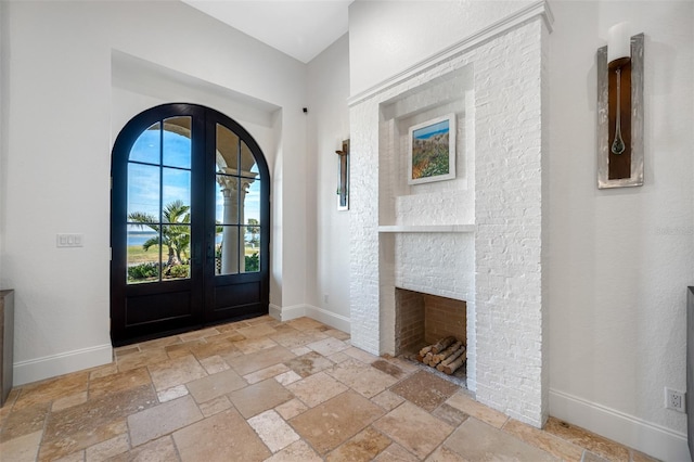 entrance foyer with french doors and a fireplace