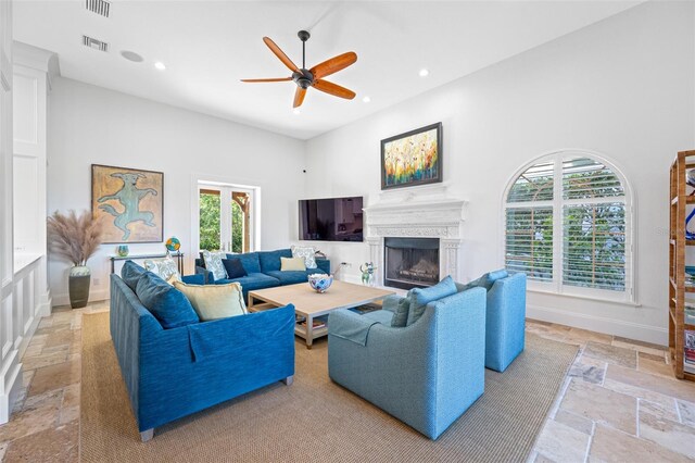 living room featuring ceiling fan and a high ceiling