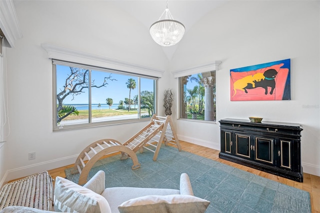 sitting room featuring high vaulted ceiling, a chandelier, and light hardwood / wood-style flooring