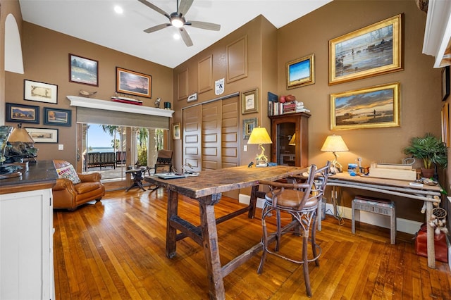 dining space with ceiling fan and wood-type flooring