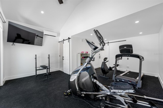 workout area featuring lofted ceiling, a barn door, and a wall unit AC