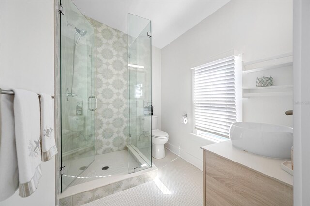 bathroom with vaulted ceiling, tile patterned flooring, vanity, a shower with shower door, and toilet