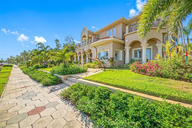 exterior space featuring a balcony and a front lawn