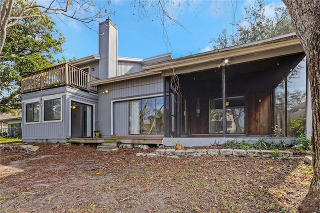 rear view of house featuring a sunroom and a balcony