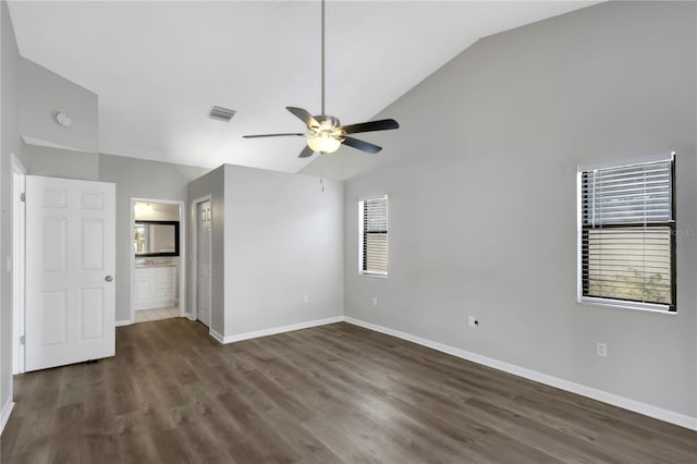 spare room with a wealth of natural light, vaulted ceiling, dark hardwood / wood-style floors, and ceiling fan