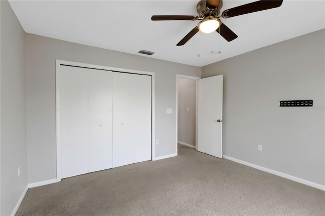 unfurnished bedroom with light colored carpet, a closet, and ceiling fan