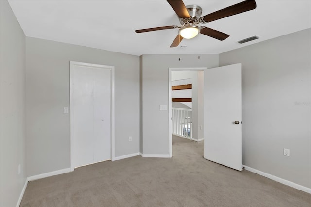 unfurnished bedroom with light carpet, ceiling fan, and a closet