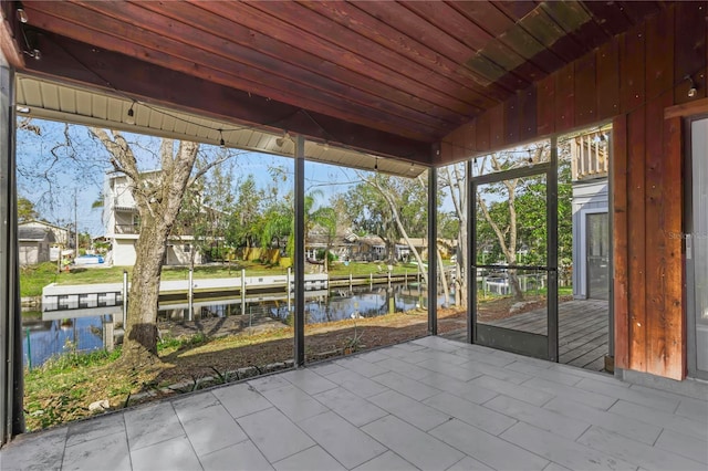 unfurnished sunroom featuring wood ceiling, vaulted ceiling, and a water view