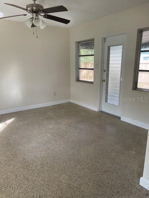 unfurnished room with ceiling fan and a wealth of natural light