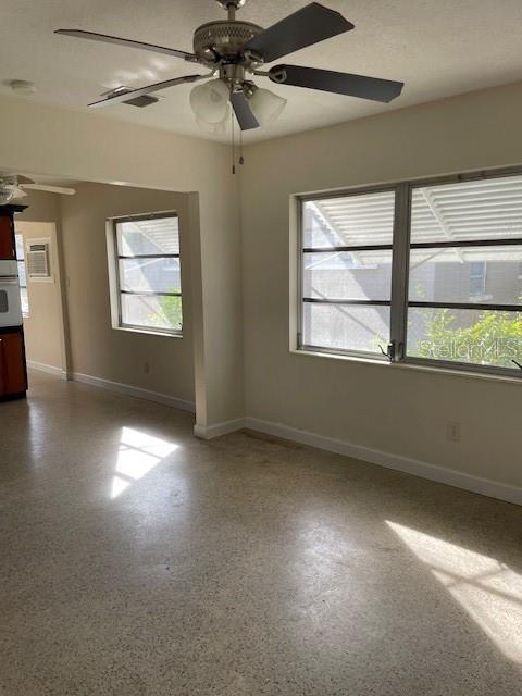 spare room with ceiling fan and a healthy amount of sunlight