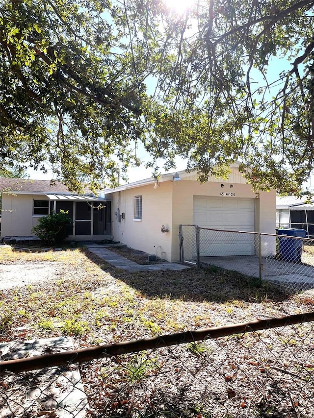 back of house featuring a garage and a sunroom