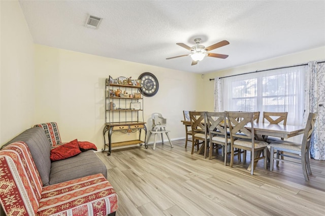 dining area featuring a textured ceiling, light hardwood / wood-style flooring, and ceiling fan