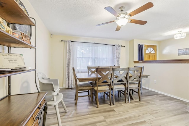 dining area with ceiling fan, a textured ceiling, and light wood-type flooring