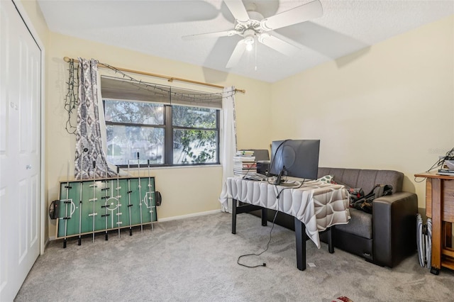 office space featuring light carpet, a textured ceiling, and ceiling fan