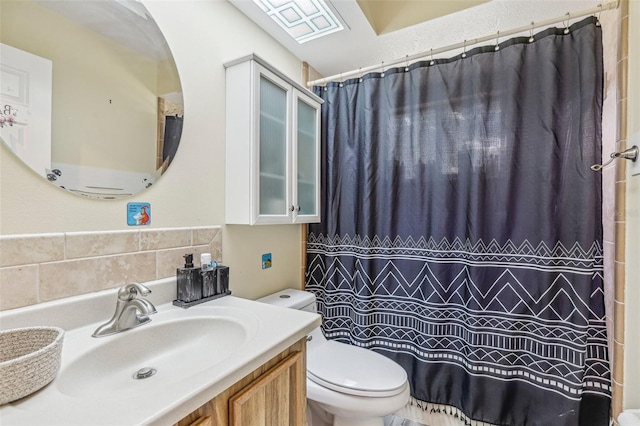 bathroom with a shower with shower curtain, vanity, and toilet