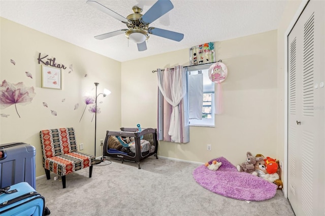 game room with carpet flooring, ceiling fan, and a textured ceiling