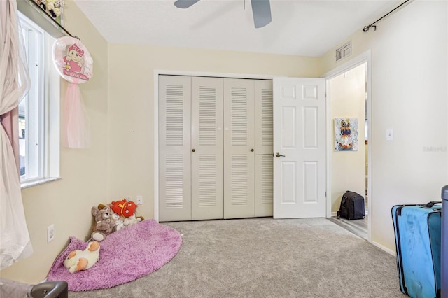 bedroom featuring light carpet, a closet, and ceiling fan