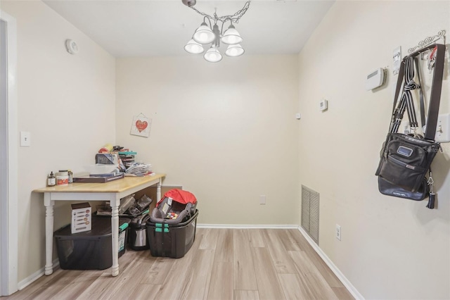 interior space with a chandelier and light hardwood / wood-style floors