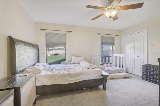 bedroom featuring ceiling fan, light carpet, and a closet