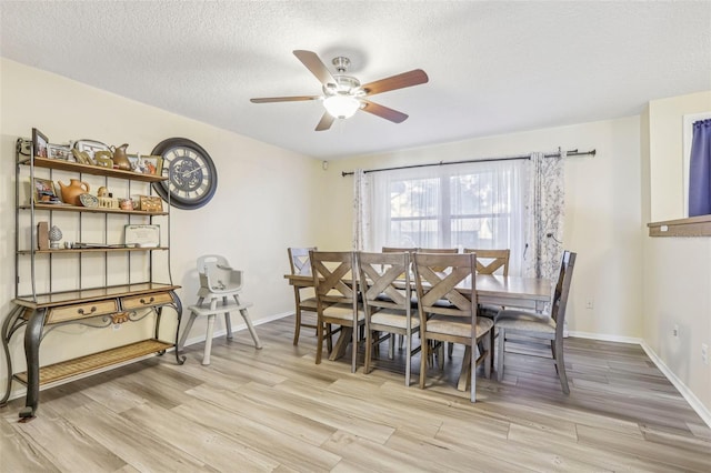 dining space featuring ceiling fan, light hardwood / wood-style floors, and a textured ceiling