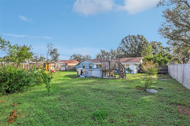 view of yard with a fenced in pool and a shed