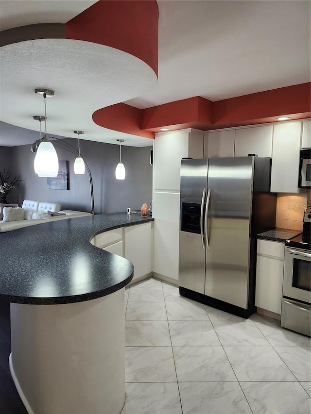 kitchen with hanging light fixtures, tasteful backsplash, a textured ceiling, white cabinets, and appliances with stainless steel finishes