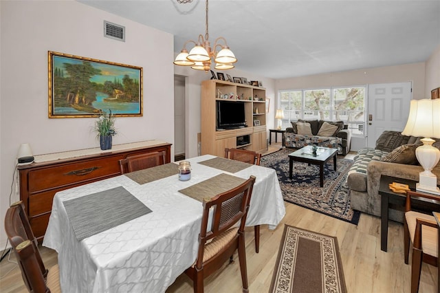 dining room featuring light hardwood / wood-style flooring and a notable chandelier