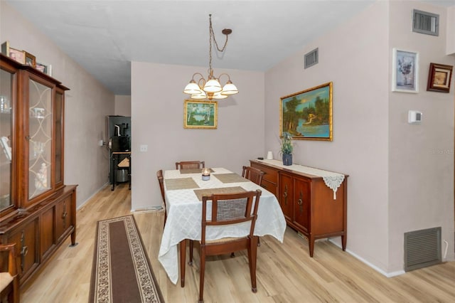 dining area featuring a notable chandelier and light wood-type flooring