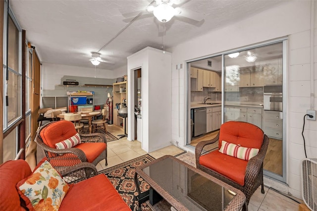 tiled living room featuring a textured ceiling, ceiling fan, and sink