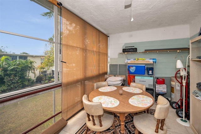 dining space with light tile patterned floors and a textured ceiling