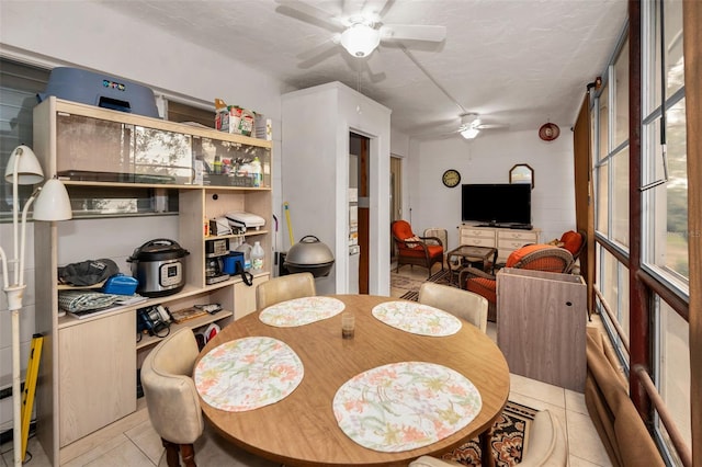 tiled dining room with ceiling fan and a textured ceiling