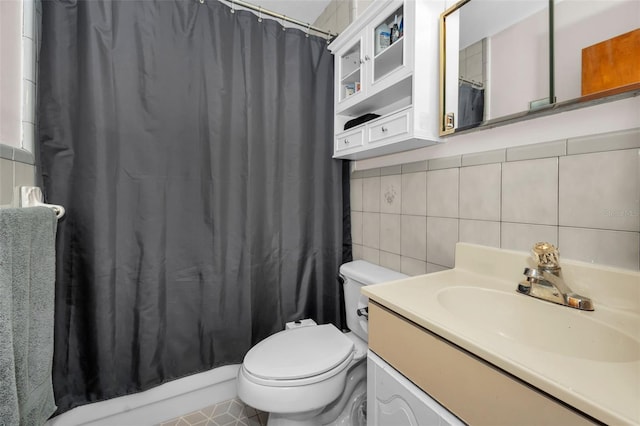 bathroom with backsplash, tile patterned floors, vanity, tile walls, and toilet