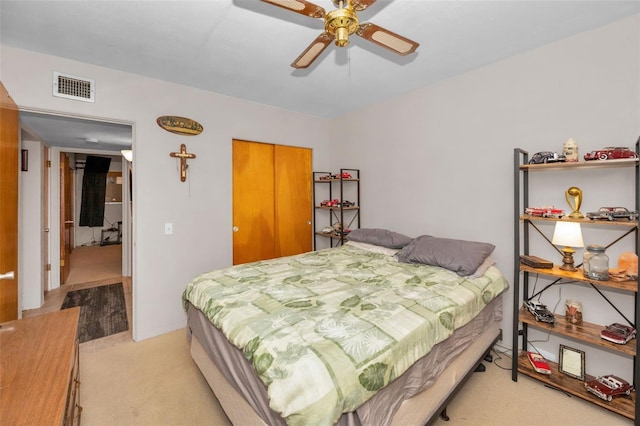 carpeted bedroom with ceiling fan and a closet