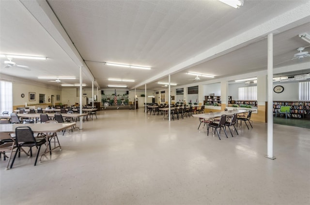 dining area featuring concrete flooring, a textured ceiling, and ceiling fan