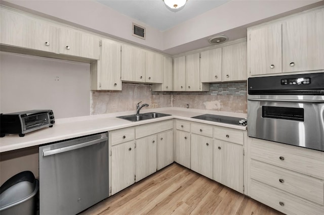 kitchen with visible vents, backsplash, light countertops, appliances with stainless steel finishes, and a sink