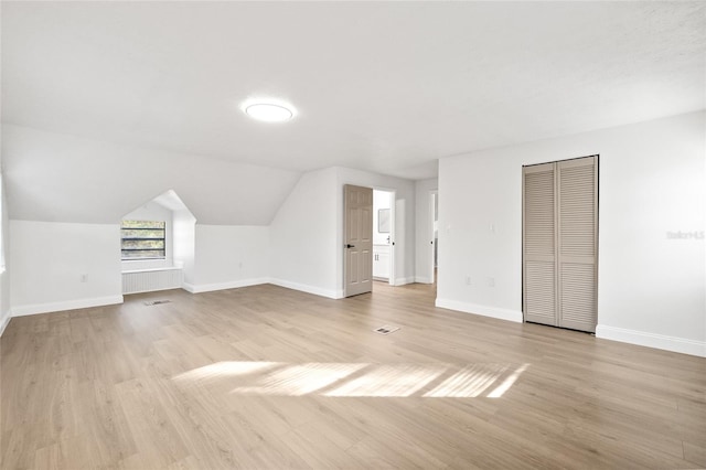 bonus room featuring vaulted ceiling and light wood-type flooring