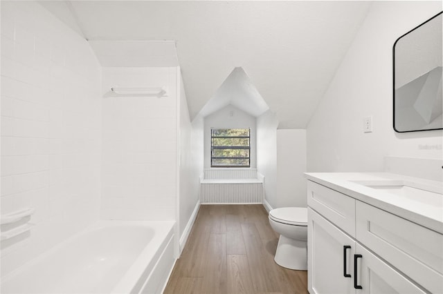 bathroom with hardwood / wood-style floors, vanity, toilet, and vaulted ceiling