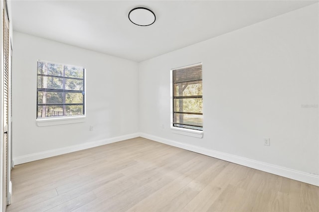 spare room with a wealth of natural light and light hardwood / wood-style flooring