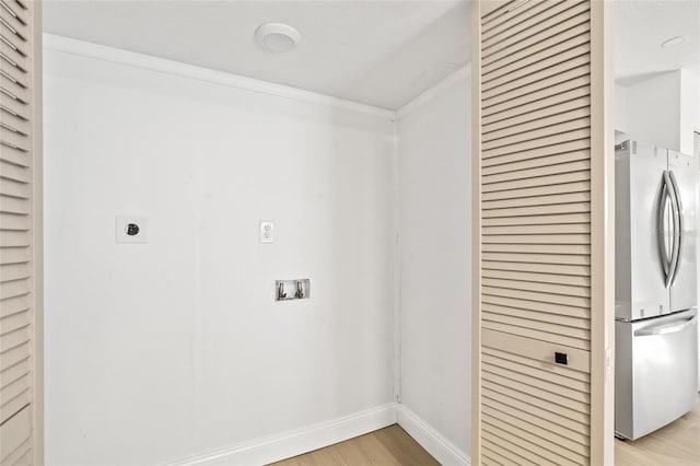 washroom featuring hookup for an electric dryer, light hardwood / wood-style flooring, and ornamental molding